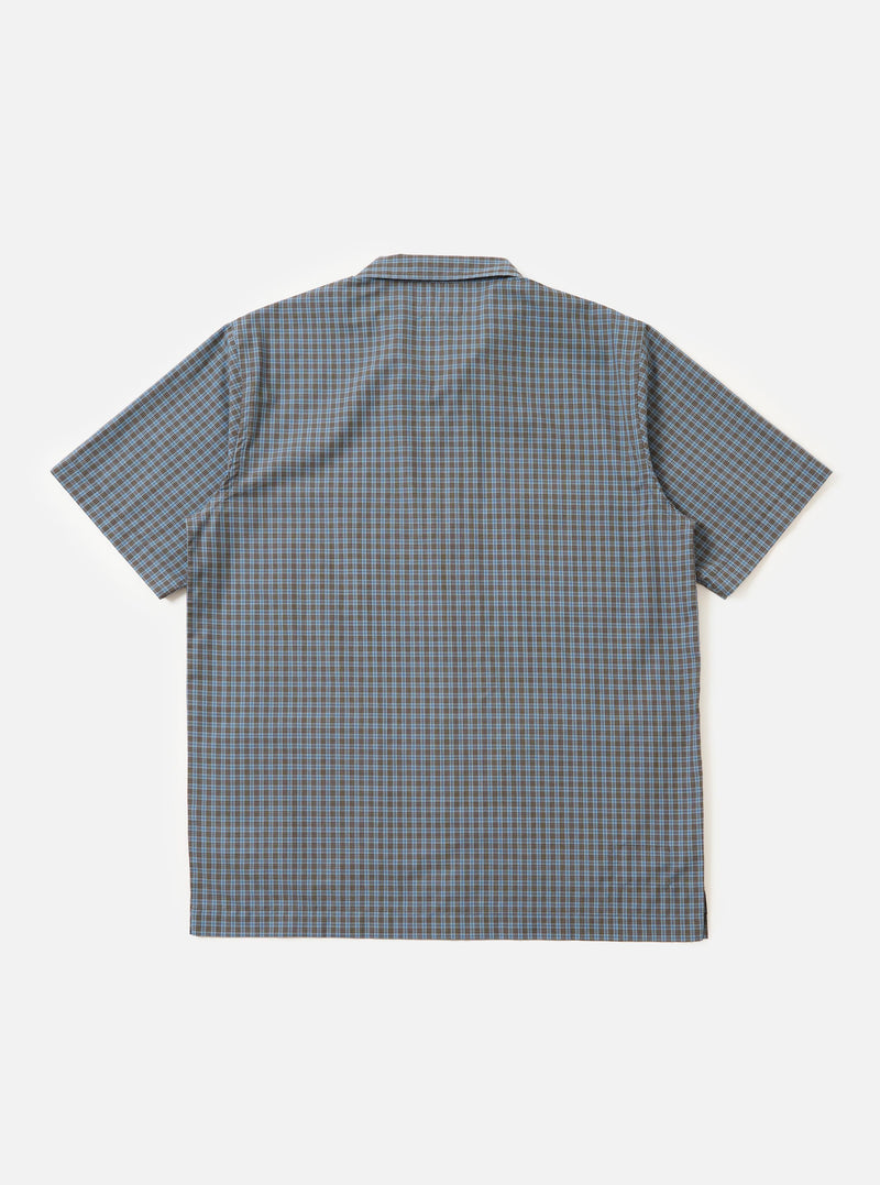 A pale blue and white check plaid summer overshirt is displayed flat against a plain white background. The garment features a pointed collar, a full button-down front, and two large patch pockets on the chest.