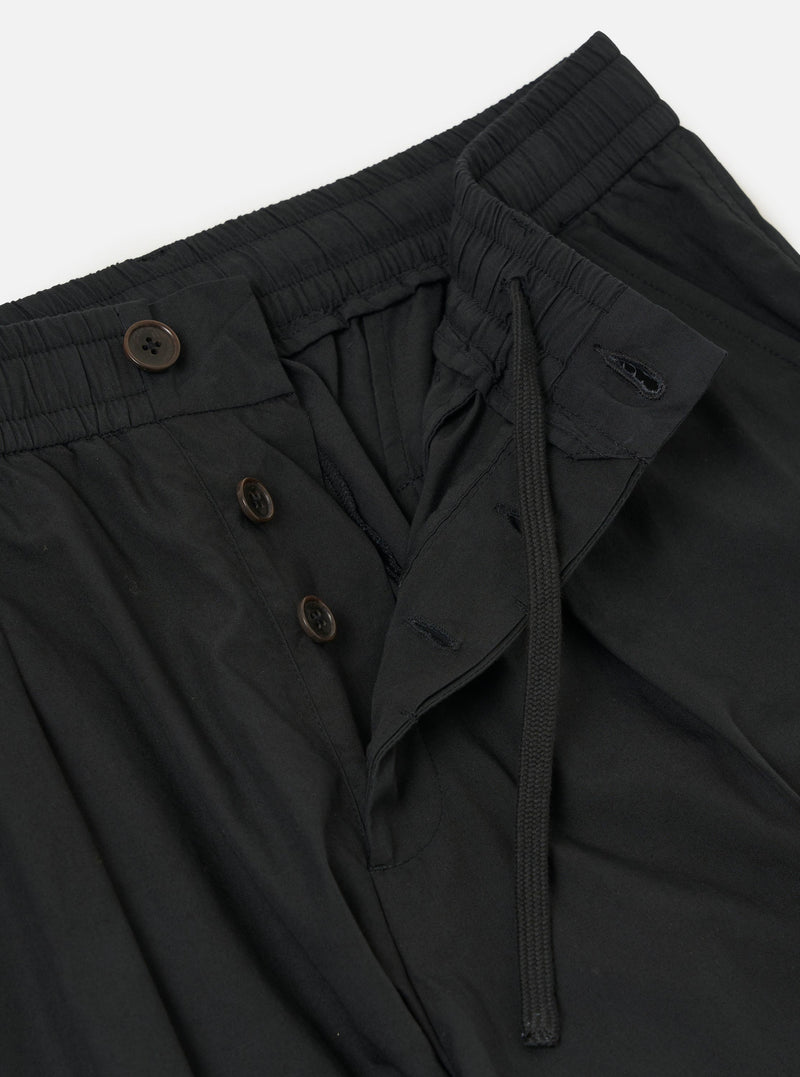 A pair of Black Broadcloth Oxford Pants is displayed from a rear view, laid flat against a solid white background. The trousers feature a wide-leg silhouette, an elasticated waistband with an internal drawstring, and a single rear buttoned flap pocket.