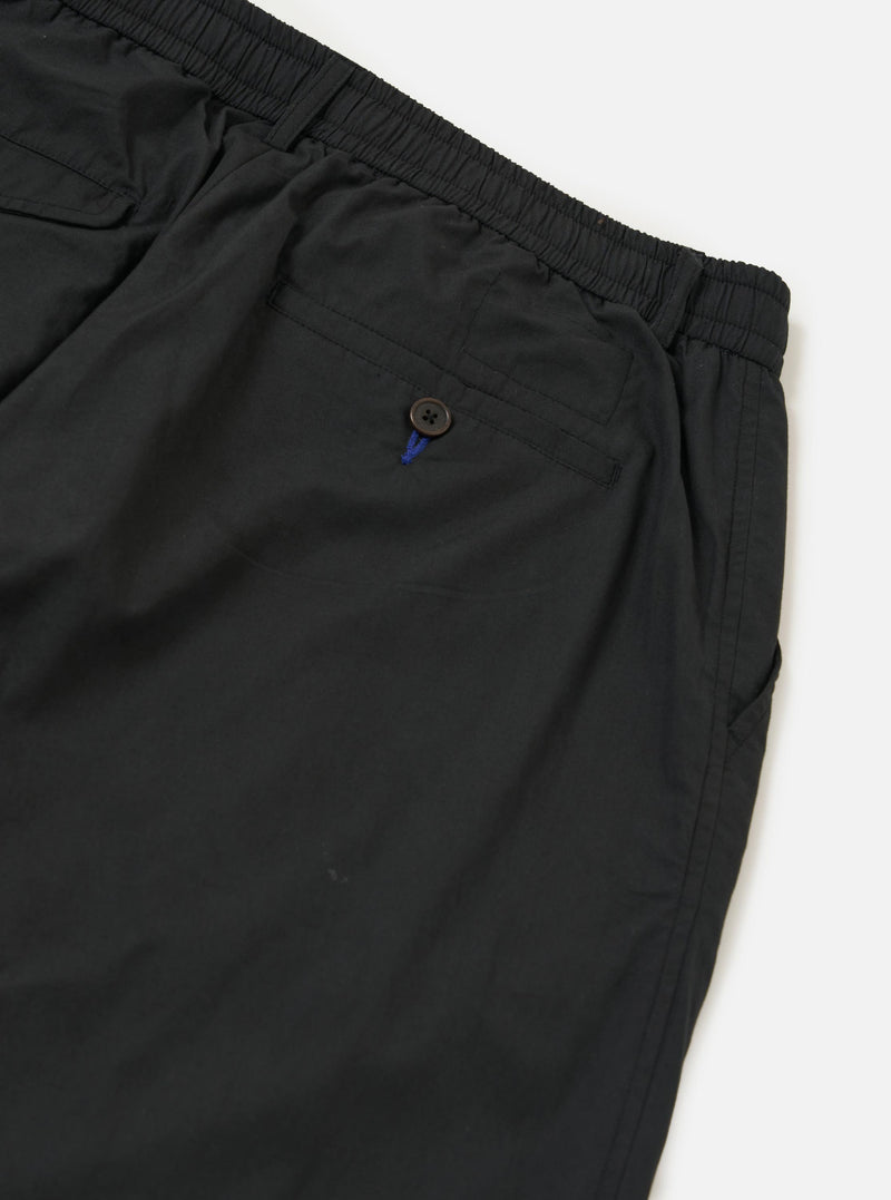 A pair of Black Broadcloth Oxford Pants is shown from the back, laid flat against a plain white background. The image highlights the rear design, featuring two buttoned flap pockets and a central belt loop.