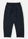 A pair of navy blue cotton broadcloth Oxford pants is displayed flat against a plain white background. The trousers feature a wide leg with a slight taper, a single front pleat, and an elasticated waistband with a white drawstring.