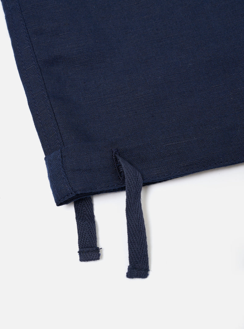 The Navy Linen Cotton Shirting Parachute Pant is shown from a rear perspective, laid flat against a solid white background. The image highlights the two large rear accordion patch pockets with buttoned flaps and the drawstring adjustable hems at the bottom of the wide legs.