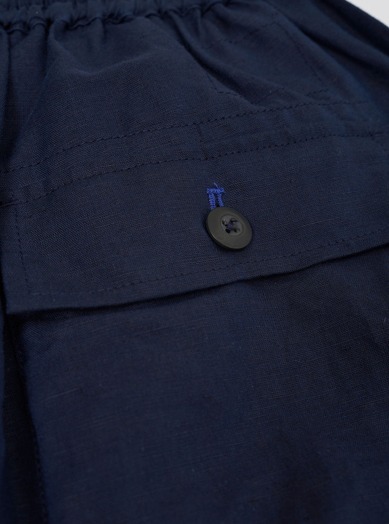 The Navy Linen Cotton Shirting Parachute Pant is shown from the back, laid flat against a plain white background. The image highlights the two large rear patch pockets, the elasticated waistband, and the relaxed, straight-leg silhouette of the dark navy trousers.