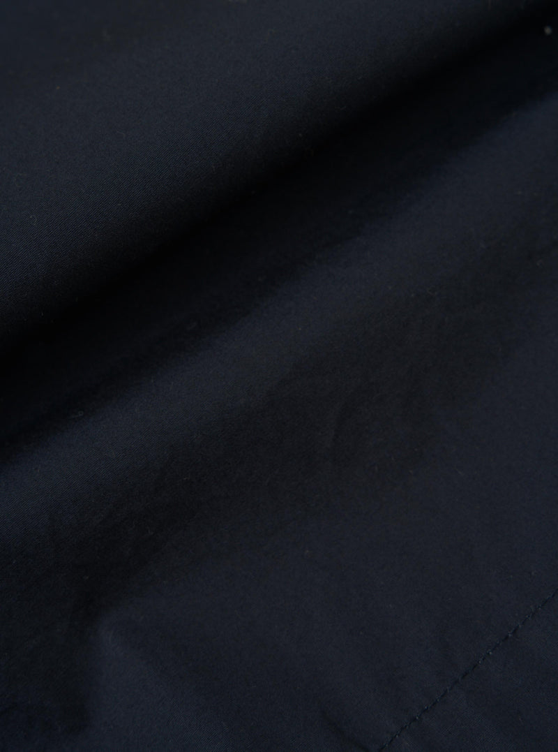 A close-up fabric swatch of the Navy Broadcloth Vacation Short shows the fine, smooth texture of the navy blue cotton material. The image focuses entirely on the fabric weave against a neutral background.