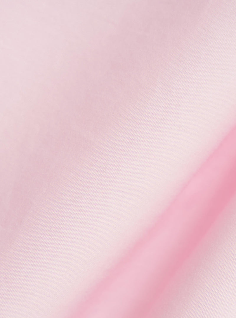 A close-up fabric swatch of the Pale Pink Broadcloth Lucky Shirt highlights the smooth, fine weave and light pink color of the material.