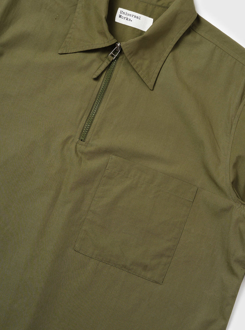 An Olive Broadcloth Ewan Shirt is shown from the back, displayed flat against a plain white background. The image highlights the short sleeves, a straight hem with side splits, and a horizontal back yoke with a central box pleat.