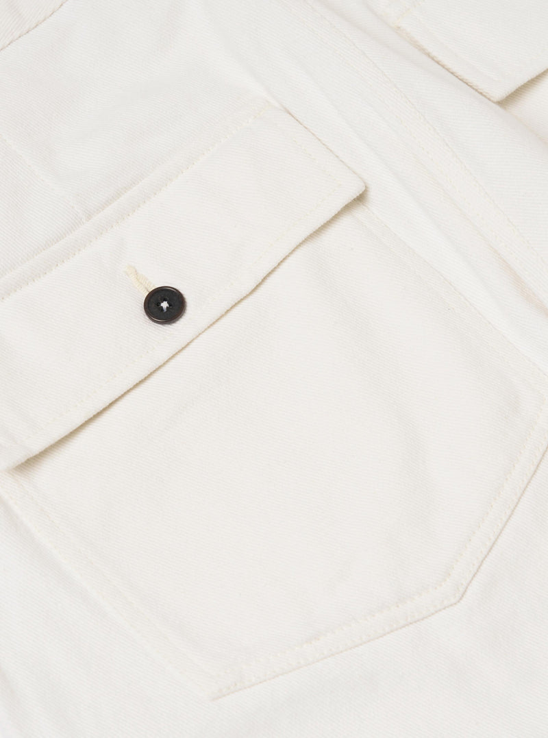 A close-up view of the back of a pair of Ecru Slub Drill Dizzy Trousers, focusing on the waistband and two rear buttoned flap patch pockets. The ecru-colored cotton fabric features a subtle slub texture and is displayed against a plain white background.