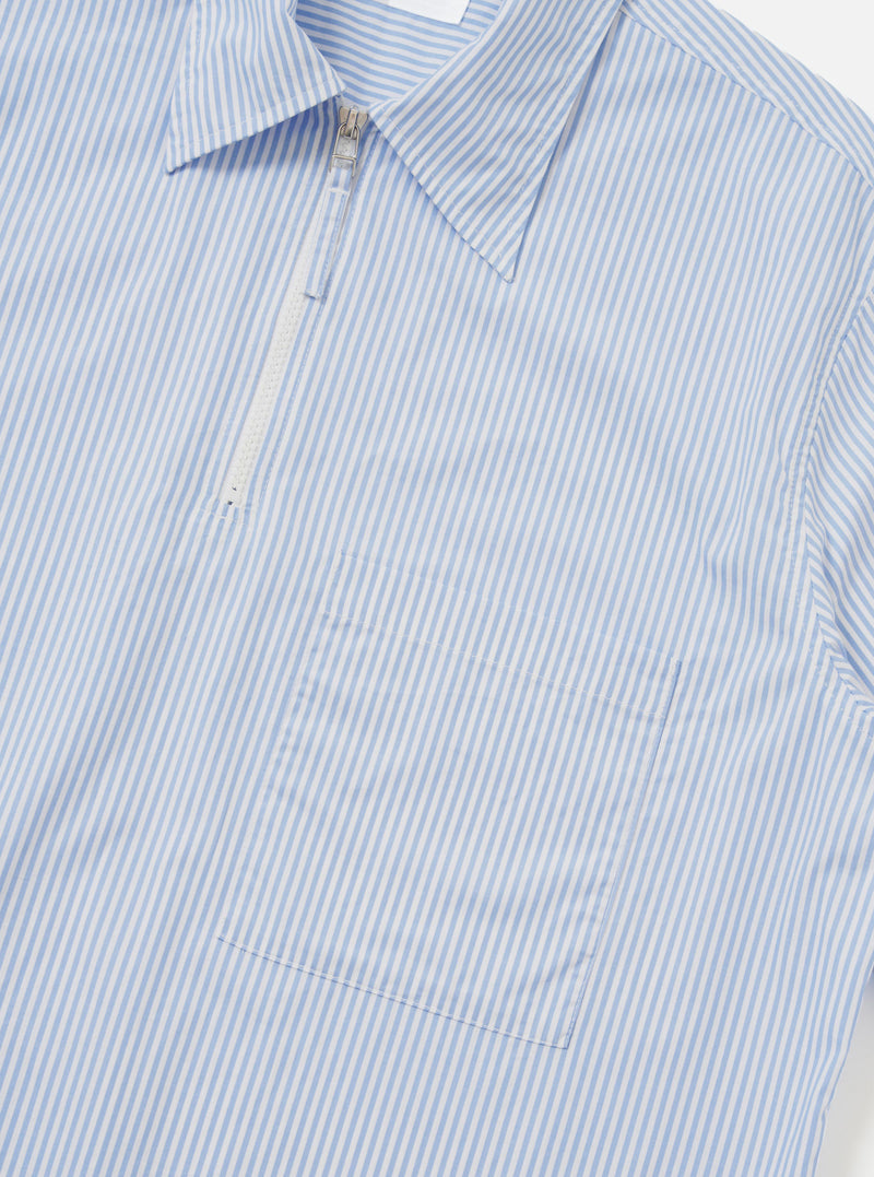 A rear view of the Sky/White Classic Nipon Stripe Ewan Shirt is shown laid flat against a plain white background. The image highlights the blue and white vertical stripes, a straight hem, and a simple horizontal yoke across the shoulders.