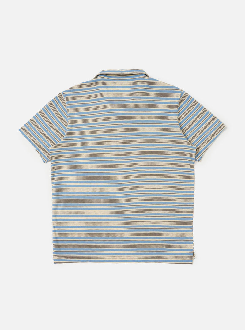The Pale Blue OS Stripe Jersey Vacation Polo is shown from the back, laid flat against a plain white background. The image highlights the horizontal light blue and white stripes, the straight hem with a slight drop, and the small side vents.