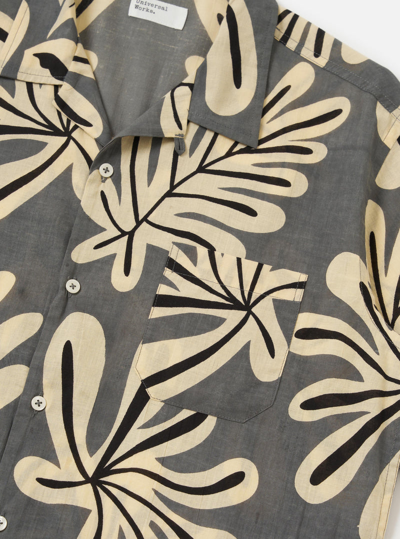The Grey Baja Print Road Shirt is shown from a rear perspective, laid flat against a plain white background. The image highlights the short-sleeve construction, a straight hem, and the detailed botanical print across the grey cotton fabric.