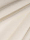 Close-up of the Paraboot x Universal Works Ecru Single Jersey Long Sleeve Tee fabric. The soft, ecru-colored jersey is draped to show its texture and quality.