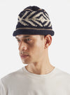 A close-up detail shot of the cableami® Navy Wool Jacquard Watch Cap against a white background, emphasizing the intricate jacquard weave texture, fine wool yarn construction, and folded cuff seam.
