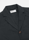 Close-up of the Black Twill London Jacket on a white background. The jacket is dark gray and made of twill. The fit is tailored. A single brown button is visible.
