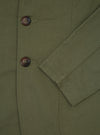Close-up of the light olive twill London jacket, showcasing the fabric texture, brown buttons, and tailored fit. Shot on a plain background.