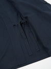 Close-up of the navy twill Kyoto Work Jacket on a white surface. The jacket features a unique tie closure and visible stitching.