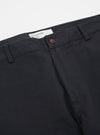 Close-up of the Black Twill Aston Pant on a white background. The dark-colored twill fabric shows a button and belt loops.