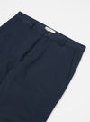 Close-up of the Navy Twill Aston Pant on a white surface. The twill fabric is a deep navy. Details include the waistband, pockets, and button closure.