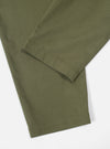 Close-up of the Light Olive Twill Pleated Track Pant on a white surface. The twill fabric is visible, showcasing the texture and color of the pants.