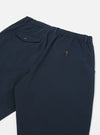 Close-up of the back of the Navy Twill Pleated Track Pant on a white surface. Shows the elastic waistband and buttoned pockets.