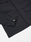 Close-up of the Black Twill MW Fatigue Jacket on a white surface. Shows the twill fabric, pockets, sleeve with button. 