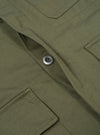 Close-up of the Light Olive Twill MW Fatigue Jacket showing the twill texture, button, and pocket details. The jacket is laid flat on a neutral surface.
