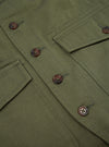 Close-up of the Light Olive Twill Field Waistcoat, showcasing the twill fabric, brown buttons, and pocket details. Shot on a flat surface.