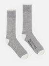 Studio shot on white background of a pair of Grey Marl Alpaca Wool Sock. The socks are grey with white toes and cuffs. One sock has the brand name printed on it.