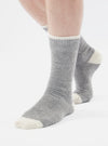 Close-up of a person wearing Grey Marl Alpaca Wool Sock on a white background. The sock is grey with a white cuff and toe.