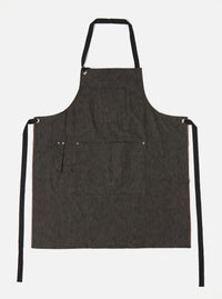 Studio shot of a Black Selvedge Denim Apron on a white background. The apron has black straps and multiple pockets.