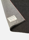 Close-up of the Black Selvedge Denim Apron showing the denim texture, red selvedge edge, and 'Universal Works' label on a white background.