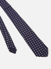 Close-up of a Navy Dot Print Tie on a white background. The tie is navy with white polka dots. The fabric has a slight sheen.