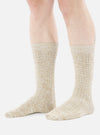 A model wears Dark Sand Slub Knit Slub Socks, showcased against a bright white backdrop. The socks are a textured knit in a neutral, sandy hue.