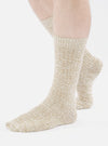 Close-up of a model wearing Dark Sand Slub Knit Slub Socks on a white background. The socks are a textured knit in a neutral, sandy color.