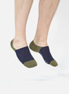 A model wearing Navy/Olive Cotton Mix Knit No Show Sock. The socks are knit and the background is a bright white.